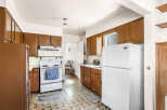 This kitchen features classic brown cabinetry offering ample storage space.