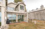 Experience breathtaking lake and mountain views from this stunning property, featuring expansive sliding glass doors that open onto a private deck.