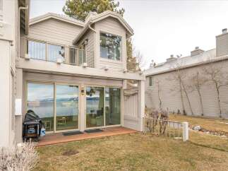 Experience breathtaking lake and mountain views from this stunning property, featuring expansive sliding glass doors that open onto a private deck.