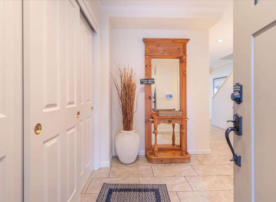Welcome guests into a warm and inviting entryway featuring a decorative wooden console table with a mirror, perfect for last-minute touch-ups.
