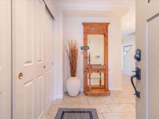 Welcome guests into a warm and inviting entryway featuring a decorative wooden console table with a mirror, perfect for last-minute touch-ups.