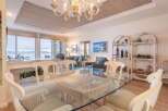 Enjoy breathtaking lake and mountain views from this stunning dining area, featuring a glass-top table and comfortable seating.