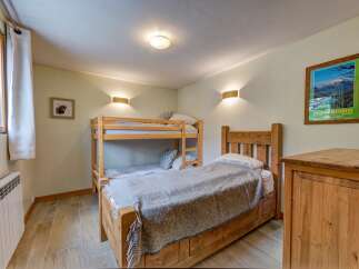This charming bedroom features a cozy bunk bed and a single bed, perfect for families or groups.