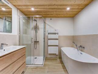 Experience modern luxury in this stunning bathroom, featuring a sleek glass-enclosed shower and a freestanding soaking tub perfect for relaxation.