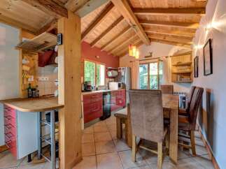 Experience rustic charm in this cozy kitchen and dining area, featuring exposed wooden beams and a warm, inviting atmosphere.