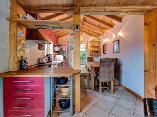 This charming kitchen boasts a rustic wooden ceiling and exposed beams, creating a warm and inviting atmosphere.