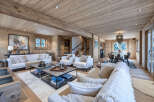 Experience luxurious mountain living in this stunning chalet, featuring a spacious open-plan living area with a cozy fireplace and ample seating.