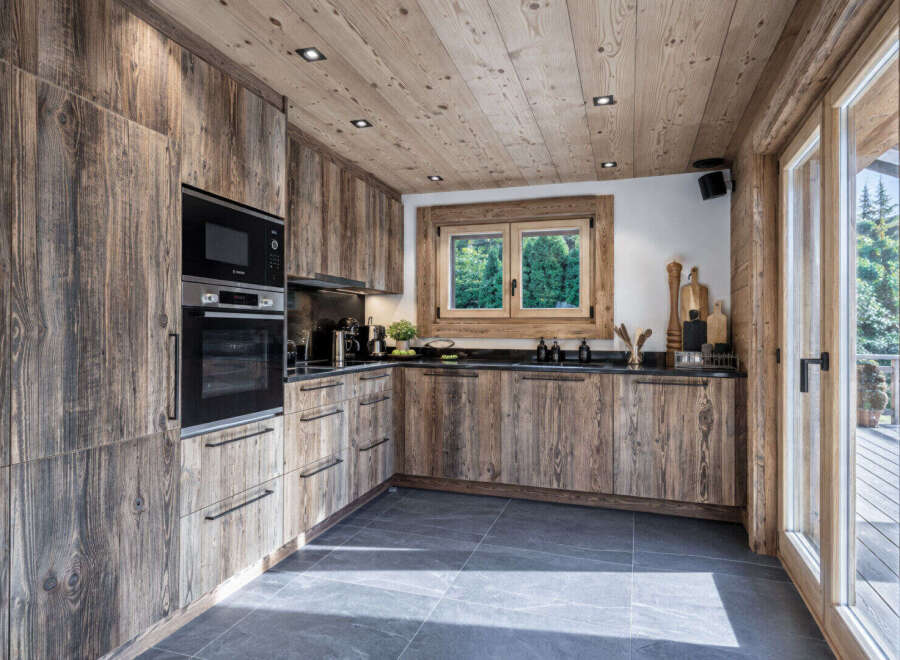 Experience rustic charm in this mountain-inspired kitchen, featuring custom wood cabinetry with a weathered finish that adds character and warmth.