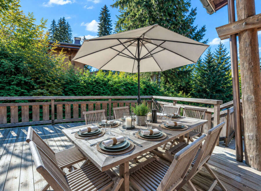 Enjoy al fresco dining on this charming wooden deck, complete with a spacious table set for six and a large umbrella for shade.