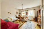 This charming living room features a cozy red sofa and a comfortable white sofa, perfect for relaxing.