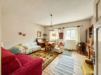 This charming living room features a cozy red sofa and a comfortable white sofa, perfect for relaxing.