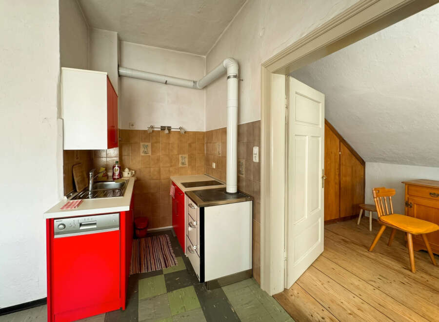 Discover this charming kitchen featuring vibrant red cabinets and a functional stovetop.