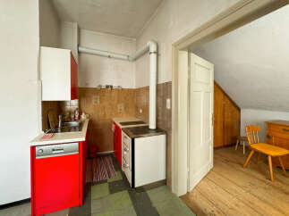 Discover this charming kitchen featuring vibrant red cabinets and a functional stovetop.
