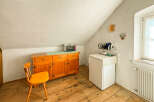 Discover this charming attic room featuring a rustic wooden floor and a sloped ceiling.