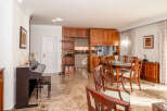 This elegant dining and living area features a rich wooden dining set with upholstered chairs, perfect for hosting gatherings.
