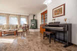 Experience elegant living in this spacious room, featuring a comfortable sofa, a stylish coffee table, and a beautiful green tiled stove.