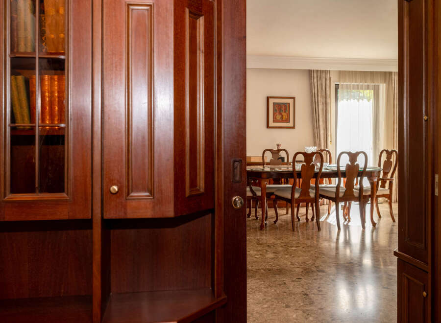 Step into a world of refined elegance with this stunning dining room, featuring a classic wooden table and chairs set against a backdrop of warm, inviting decor.