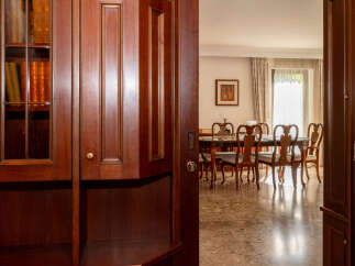 Step into a world of refined elegance with this stunning dining room, featuring a classic wooden table and chairs set against a backdrop of warm, inviting decor.