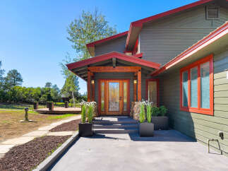 Welcome to this charming home featuring a beautiful wooden front door with stained glass accents, leading into a welcoming entryway.