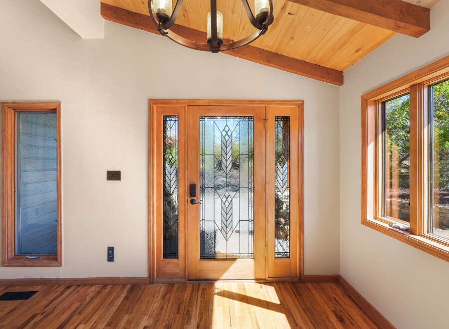 Step into this inviting entryway featuring a stunning double door with intricate stained glass panels, flooding the space with natural light.