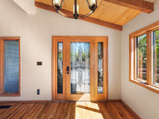 Step into this inviting entryway featuring a stunning double door with intricate stained glass panels, flooding the space with natural light.