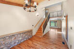 Step into this inviting entryway featuring a stunning stone accent wall and gleaming hardwood floors.