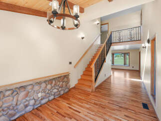 Step into this inviting entryway featuring a stunning stone accent wall and gleaming hardwood floors.