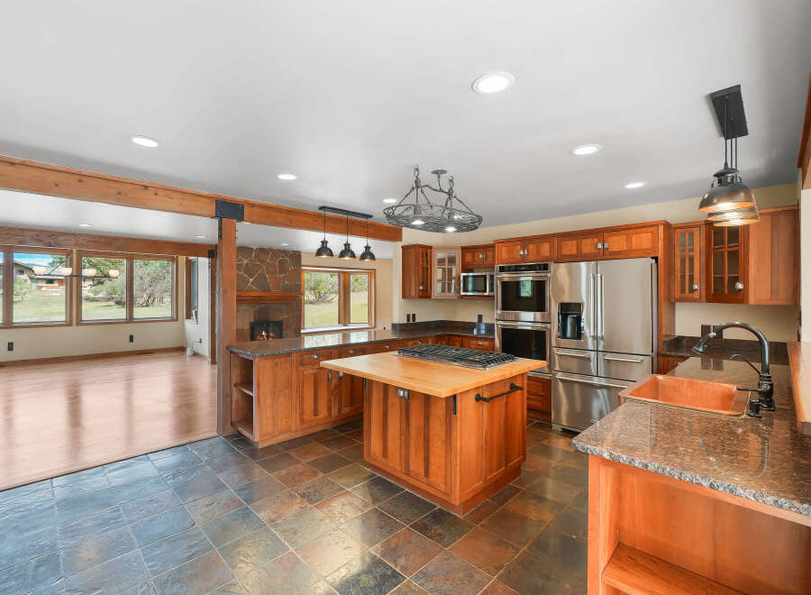 Experience the warmth and elegance of this spacious kitchen, featuring rich cherry wood cabinetry and granite countertops.