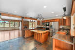Experience the warmth and elegance of this spacious kitchen, featuring rich cherry wood cabinetry and granite countertops.