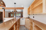 This spacious kitchen features a large wooden countertop bar with ample shelving below, perfect for entertaining.