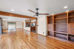 This spacious open-concept living area boasts beautiful hardwood floors and exposed wooden beams, creating a warm and inviting atmosphere.