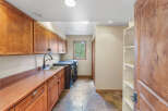 This spacious laundry room boasts ample storage with custom wooden cabinetry and open shelving.