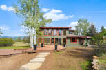 Experience modern living in this stunning home featuring a spacious wooden deck perfect for outdoor entertaining.