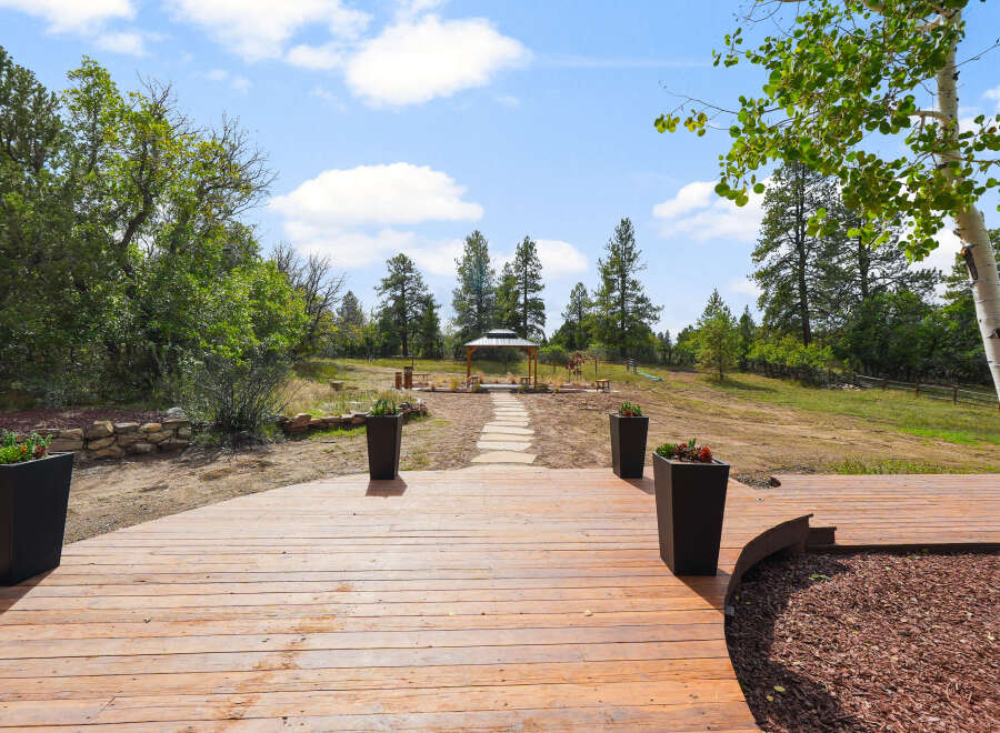 Step onto a spacious wooden deck, perfect for outdoor entertaining and enjoying the serene natural surroundings.