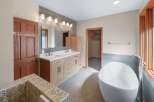 This spacious bathroom features a modern freestanding bathtub and a double vanity with ample storage.