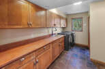 This laundry room boasts ample storage with custom wooden cabinetry, both above and below the countertop.