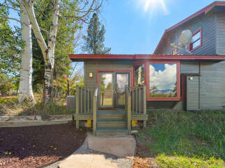 Embrace the mountain lifestyle with this charming home, featuring a welcoming deck and large windows that capture stunning natural light and scenic views.