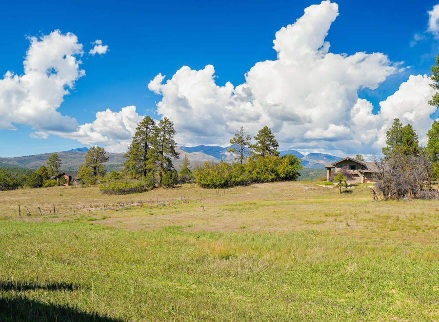 Nestled amidst rolling hills and mature pine trees, this property offers a serene retreat with breathtaking mountain views.