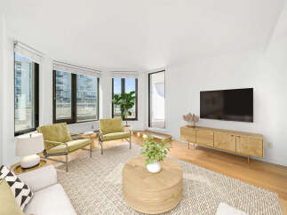Experience modern living in this bright and airy living room, featuring large windows that flood the space with natural light and offer city views.