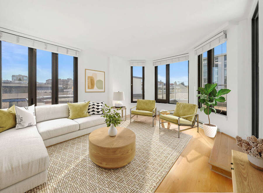 Experience modern living in this bright and airy living room, featuring a spacious sectional sofa and two accent chairs perfect for entertaining.