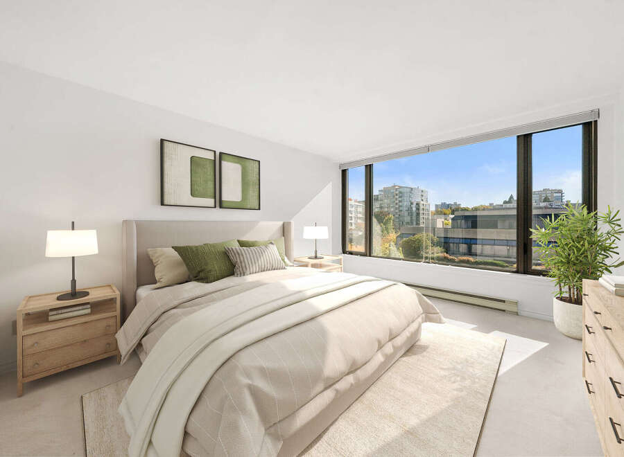 Experience modern living in this beautifully appointed bedroom, featuring a plush king-sized bed adorned with comfortable green and striped pillows.
