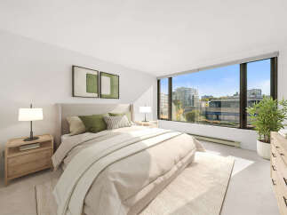 Experience modern living in this beautifully appointed bedroom, featuring a plush king-sized bed adorned with comfortable green and striped pillows.
