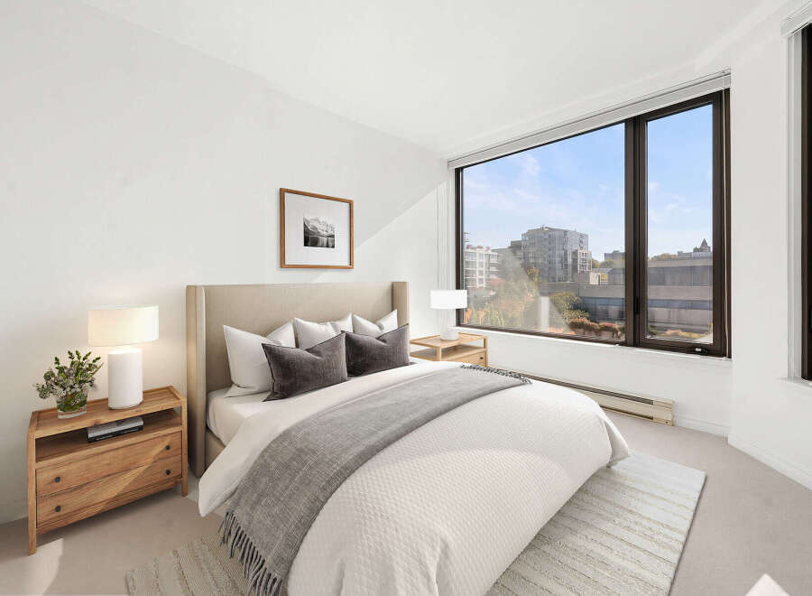 Experience modern comfort in this beautifully appointed bedroom, featuring a plush king-sized bed with elegant grey accents and a cozy throw.