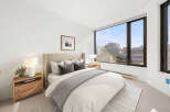 Experience modern comfort in this beautifully appointed bedroom, featuring a plush king-sized bed with elegant grey accents and a cozy throw.