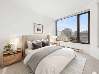 Experience modern comfort in this beautifully appointed bedroom, featuring a plush king-sized bed with elegant grey accents and a cozy throw.