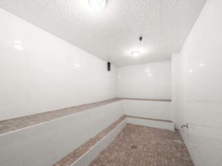 Experience ultimate relaxation in this pristine steam room, featuring tiered seating perfect for unwinding.