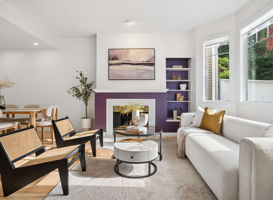 Step into this inviting living room, featuring a striking purple fireplace as the focal point, complemented by a modern abstract painting above.