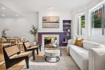Step into this inviting living room, featuring a striking purple fireplace as the focal point, complemented by a modern abstract painting above.