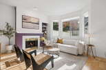 Step into this inviting living room, bathed in natural light from large bay windows.