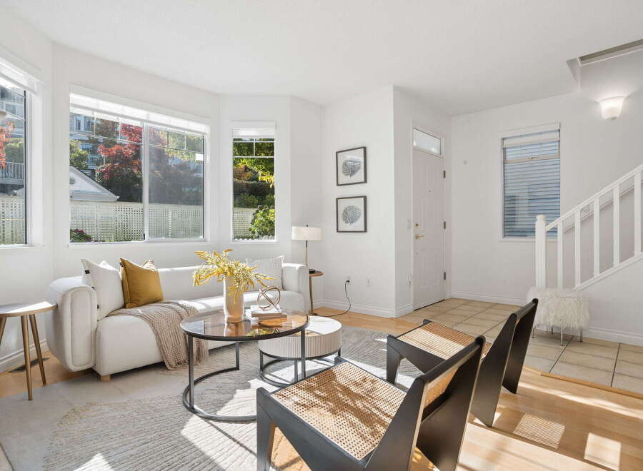 Step into this bright and airy living room, bathed in natural light from large bay windows offering picturesque views of autumn foliage.